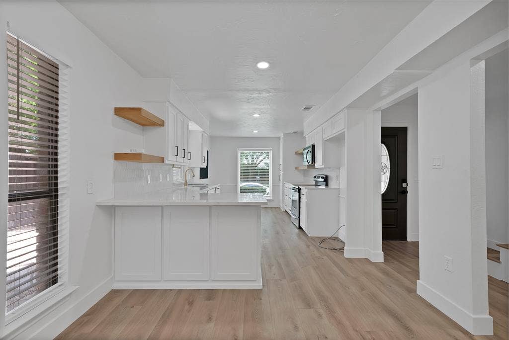 4021 San Mateo Drive, Plano, TX 75093 Modern kitchen with white cabinetry and light-tone wood-finish flooring
