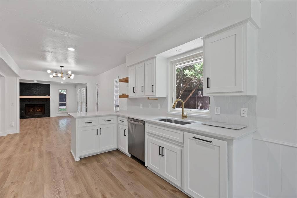 4021 San Mateo Drive, Plano, TX 75093 Bright kitchen featuring white shaker cabinetry, stainless steel dishwasher, and a gold-finish faucet