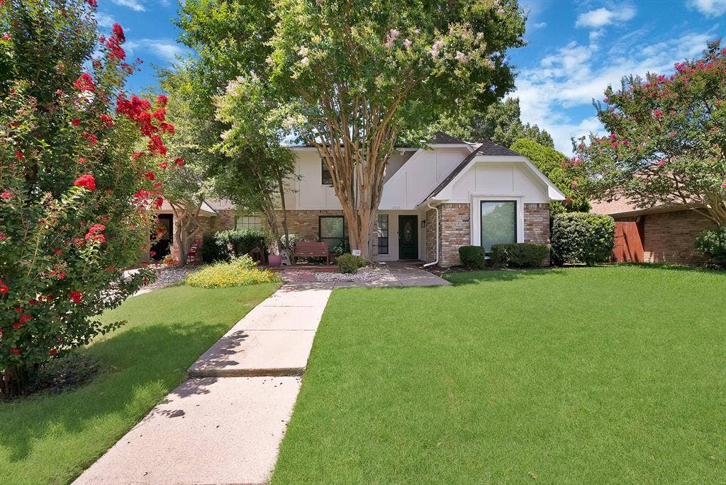4021 San Mateo Drive, Plano, TX 75093 Traditional-style residence featuring a brick and siding exterior, established landscaping, and a concrete pathway
