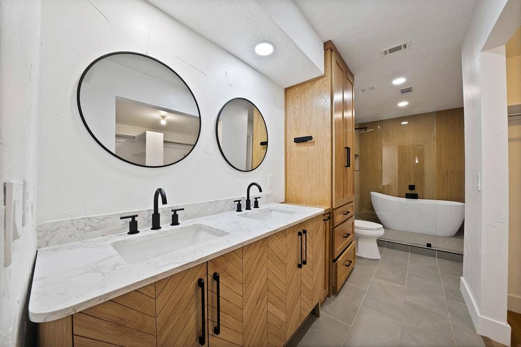 4021 San Mateo Drive, Plano, TX 75093 Dual vanity with marble-finish countertop, undermount sinks, and matte black fixtures