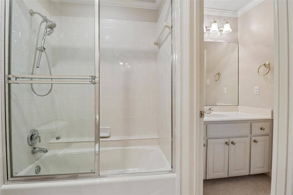 2600 Saratoga, McKinney, TX 75070 Bathtub with sliding glass enclosure, white tile surround, and built-in bench