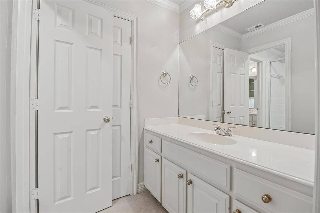 2600 Saratoga, McKinney, TX 75070 White vanity with integrated sink, chrome faucet, and expansive wall mirror