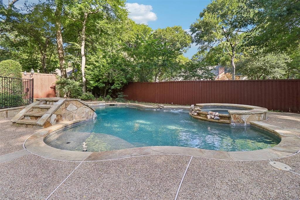 2600 Saratoga, McKinney, TX 75070 Freeform swimming pool featuring a stone-clad hot tub and integrated stone steps
