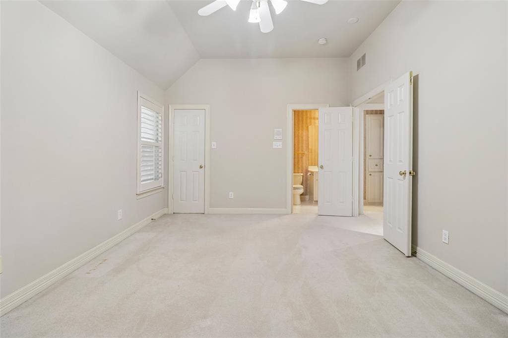 2600 Saratoga, McKinney, TX 75070 Vaulted ceiling with a ceiling fan, white paneled doors, window with plantation shutters, and light-toned carpeting