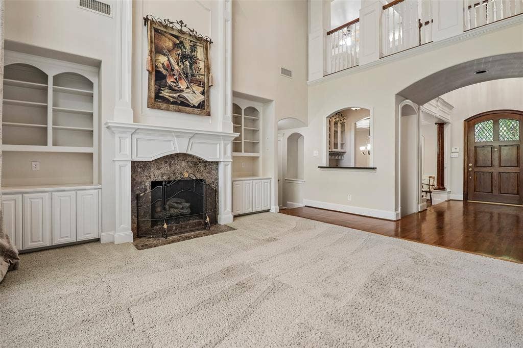 2600 Saratoga, McKinney, TX 75070 Central fireplace with stone surround and classic mantel, flanked by built-in shelving and cabinetry