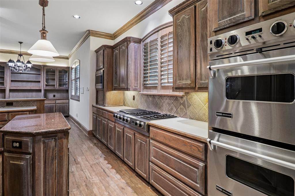 2600 Saratoga, McKinney, TX 75070 Wood-finish flooring with a kitchen island featuring a granite countertop