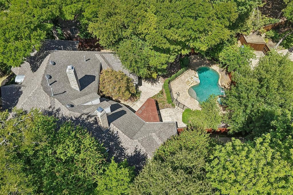 2600 Saratoga, McKinney, TX 75070 Curved swimming pool with stone surround, complemented by extensive hardscaping and mature trees