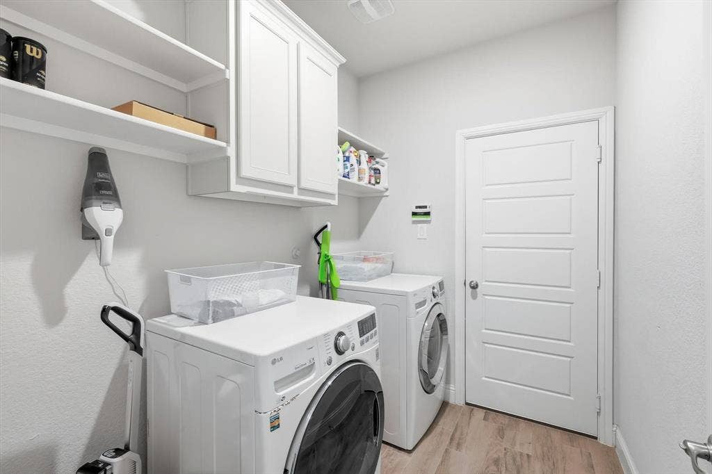 904 10th Street, Argyle, TX 76226 Dedicated laundry space featuring white wall-mounted cabinetry, open shelving, and wood-finish flooring