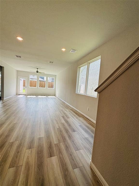 912 Santa Lucia Drive, Anna, TX 75409 Unfurnished living room with a ceiling fan, light wood-style flooring, healthy amount of natural light, and recessed lighting