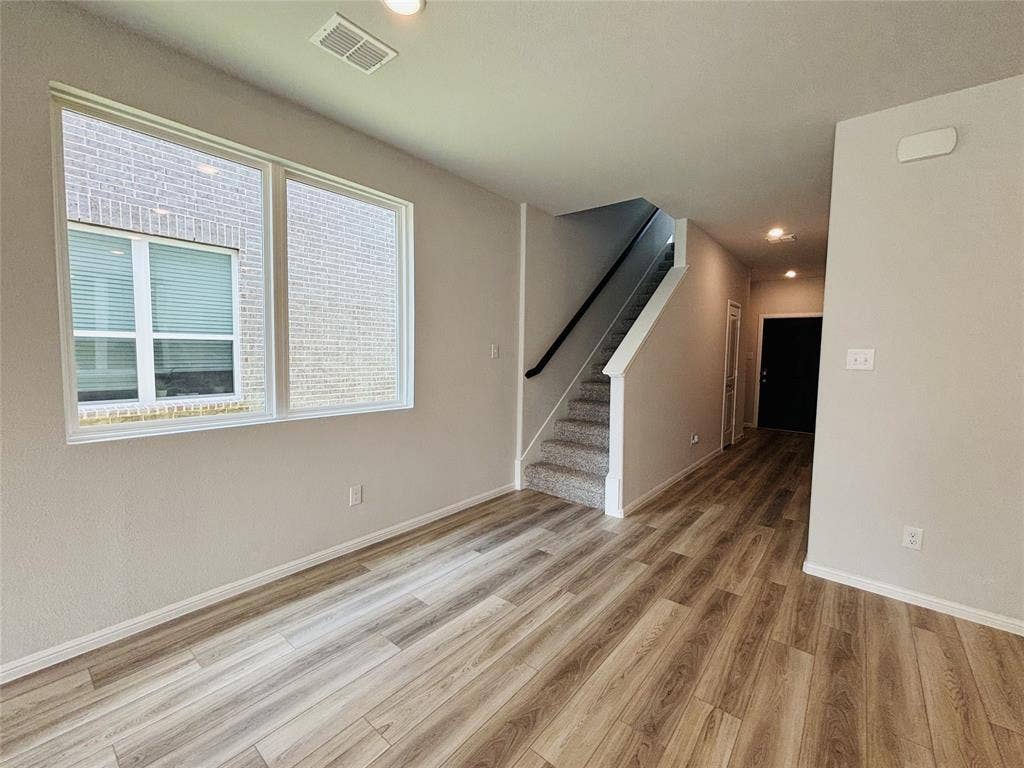 912 Santa Lucia Drive, Anna, TX 75409 Unfurnished living room with light wood-style flooring, stairs, and recessed lighting