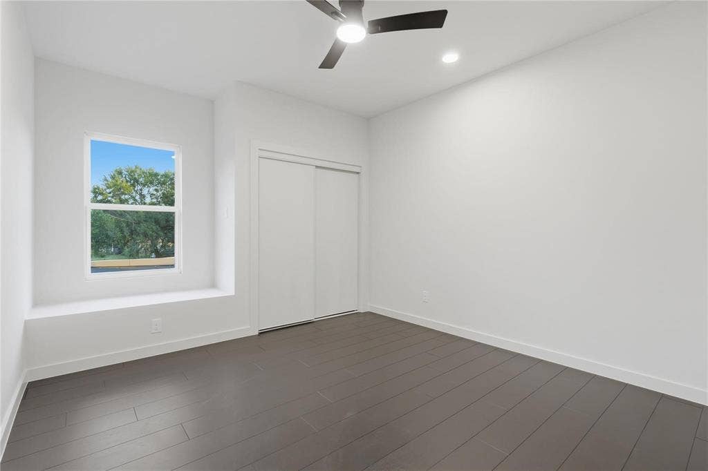 Bright room featuring dark wood-finish flooring, a contemporary ceiling fan, and recessed lighting