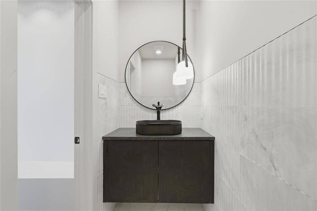 Floating vanity with a dark wood-finish cabinet and a charcoal vessel sink
