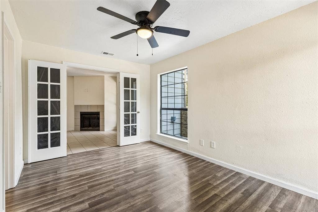 6108 Abrams Road, #610, Dallas, TX 75231 Interior room featuring wood-finish flooring, a window with grid detailing, and a ceiling fan with integrated lighting