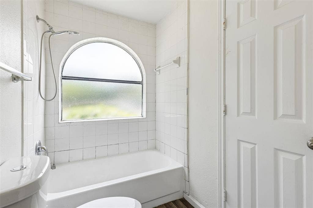 6108 Abrams Road, #610, Dallas, TX 75231 Bathroom featuring a tiled shower/tub combination with an arched privacy window