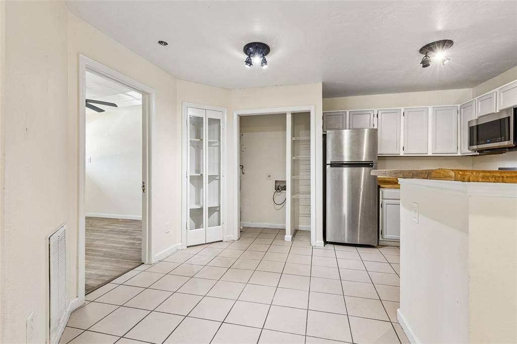 6108 Abrams Road, #610, Dallas, TX 75231 Kitchen area featuring light-toned tile flooring, light-toned cabinetry, and stainless steel appliances
