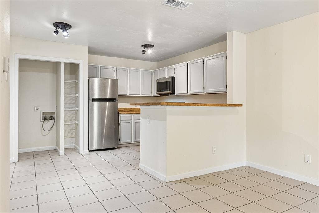 6108 Abrams Road, #610, Dallas, TX 75231 Kitchen area with tile flooring and track lighting