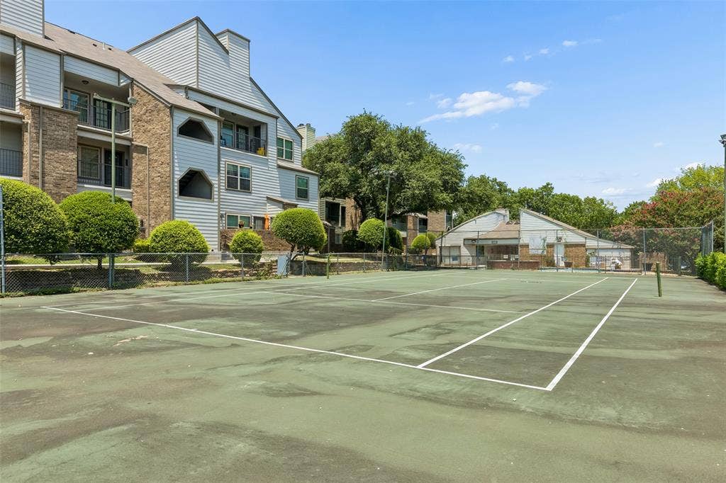 6108 Abrams Road, #610, Dallas, TX 75231 Outdoor tennis court with perimeter fencing, surrounded by mature trees and landscaping