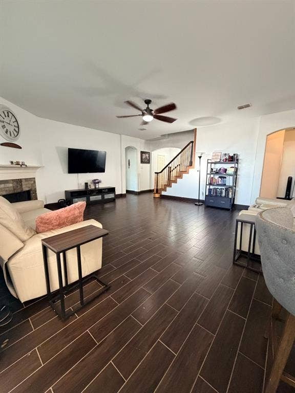 Spacious living area featuring plank-style tile flooring and a ceiling fan