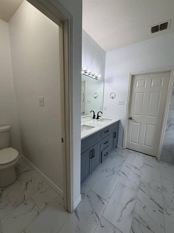 Modern bathroom featuring a dual vanity with a light gray cabinet, white countertop, and black fixtures