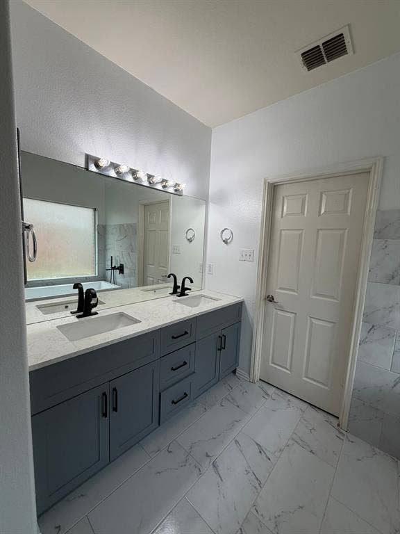 Dual vanity featuring a light gray cabinet finish, white countertops, and matte black fixtures