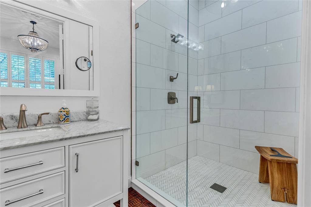 Modern bathroom featuring a glass-enclosed shower with subway tile surround and herringbone floor tile
