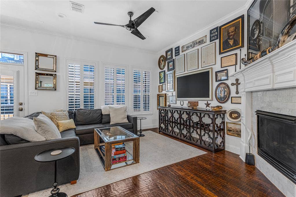 Living area featuring rich wood-finish flooring and white plantation shutters