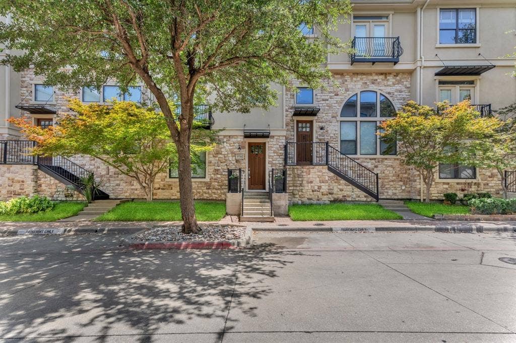 Multi-story townhome exterior featuring stone and stucco finishes