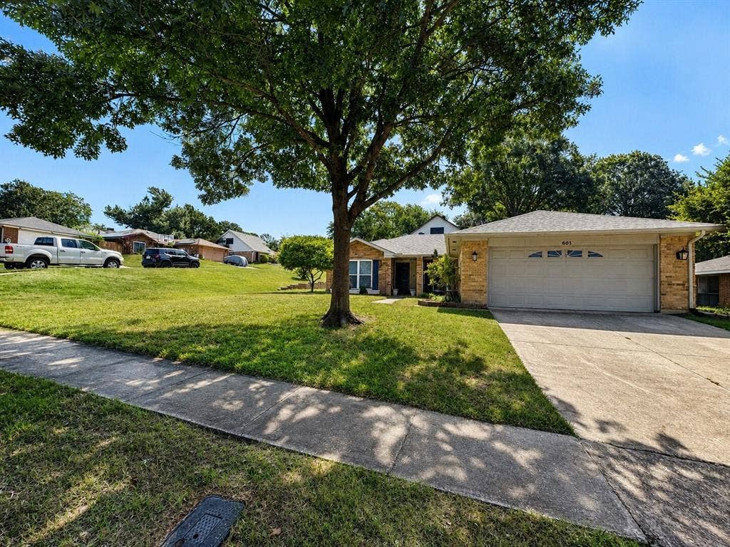601 Ascot Drive, Euless, TX 76040 Single-story residence featuring a brick facade, attached two-car garage, and a concrete driveway