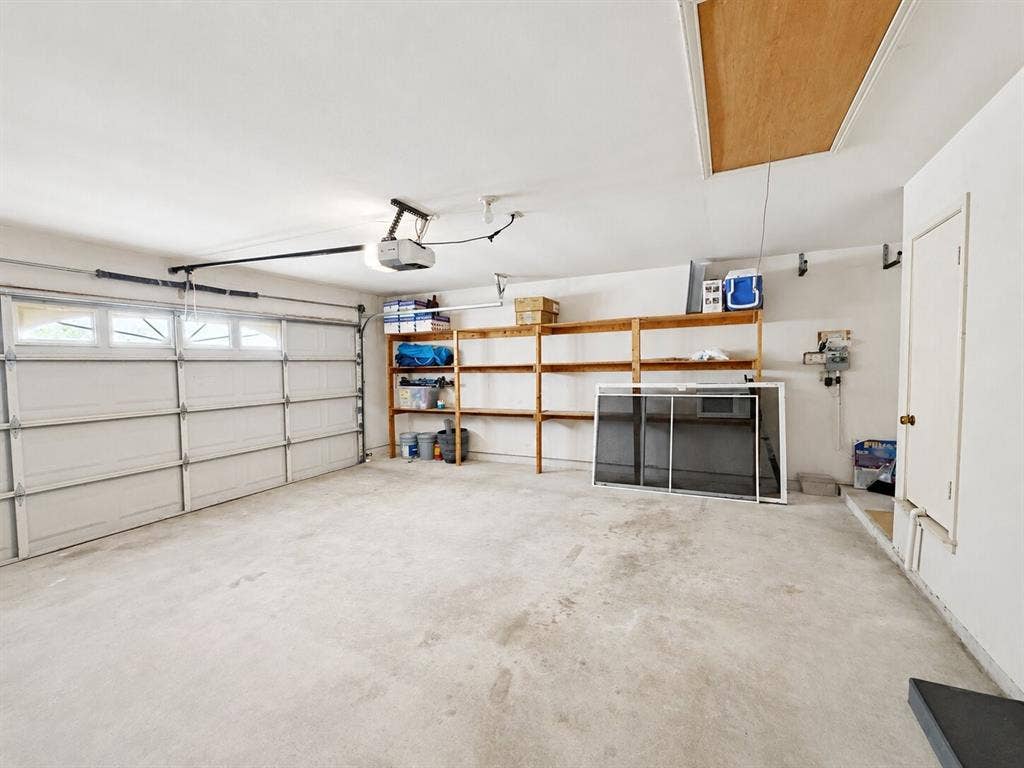 601 Ascot Drive, Euless, TX 76040 Spacious garage featuring a sectional garage door with upper windows and an automatic opener