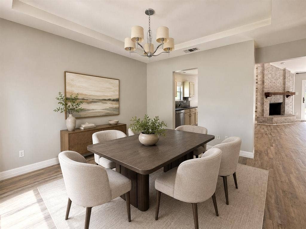 601 Ascot Drive, Euless, TX 76040 Dining area featuring wood-finish flooring, a tray ceiling, and a chandelier