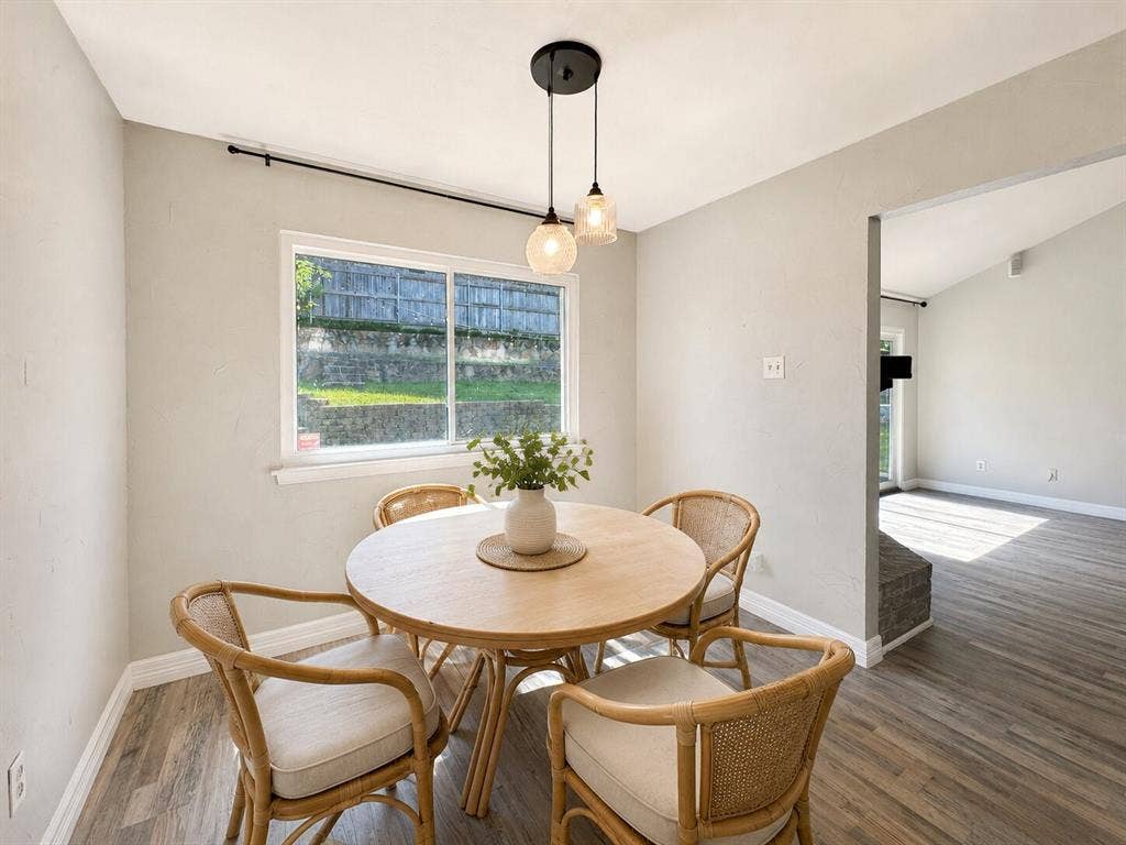 601 Ascot Drive, Euless, TX 76040 Dining area featuring a contemporary pendant light fixture, a large window, light gray walls, and wood-finish flooring