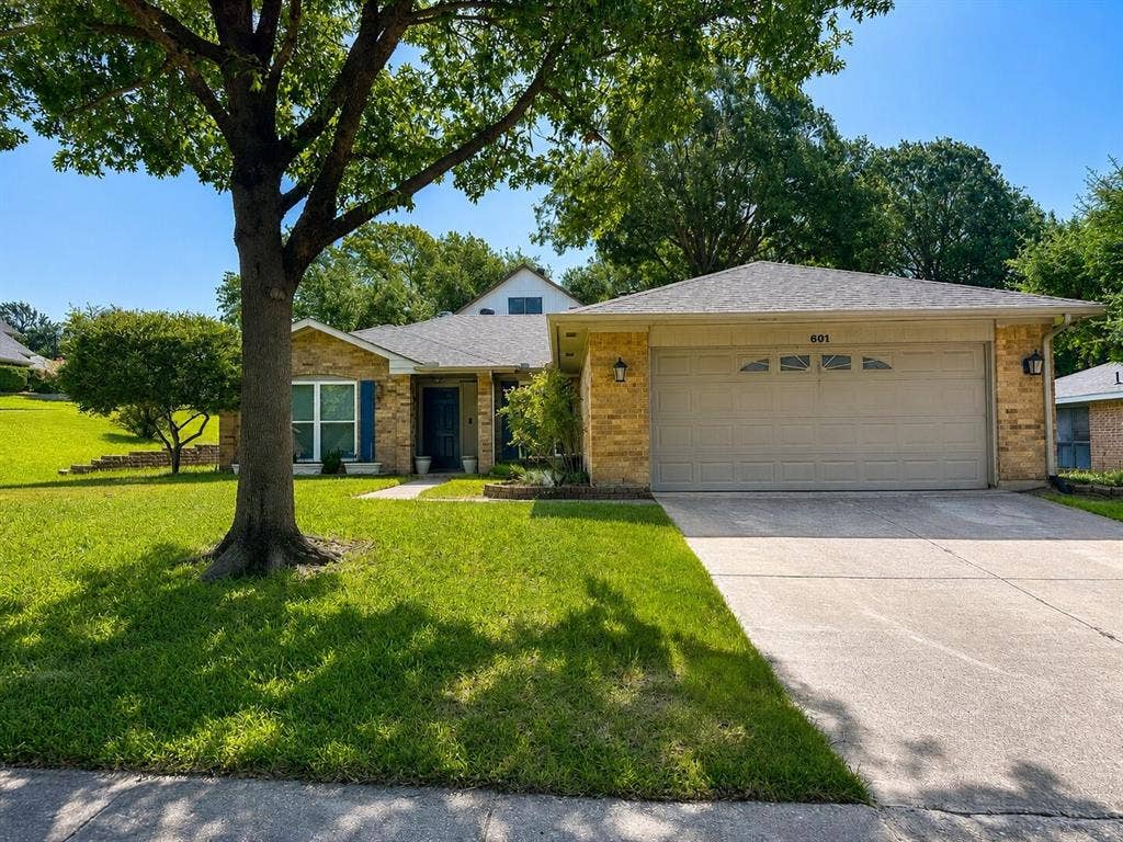 601 Ascot Drive, Euless, TX 76040 Single-story residence featuring a brick facade and an attached two-car garage with transom window accents
