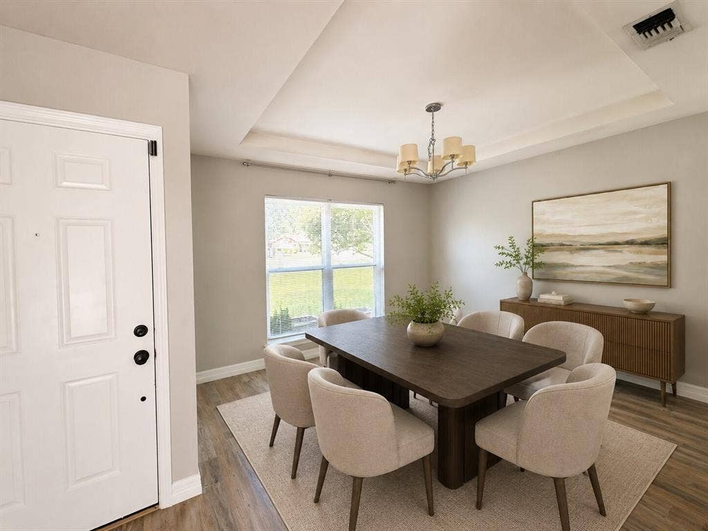 601 Ascot Drive, Euless, TX 76040 Dining space featuring a tray ceiling, chandelier lighting, and wood-finish flooring