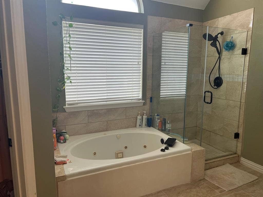Jetted soaking tub with a tiled surround, complemented by a walk-in shower with a glass enclosure and matte black fixtures