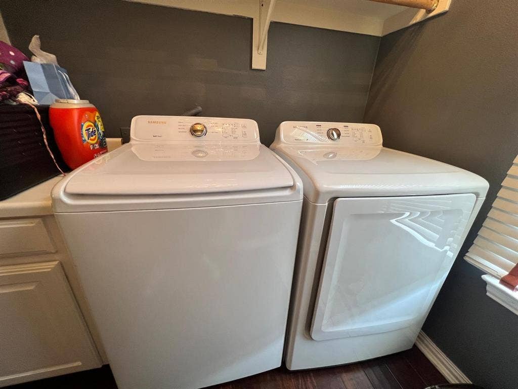 Dedicated laundry area featuring a white top-load washing machine and white front-load dryer
