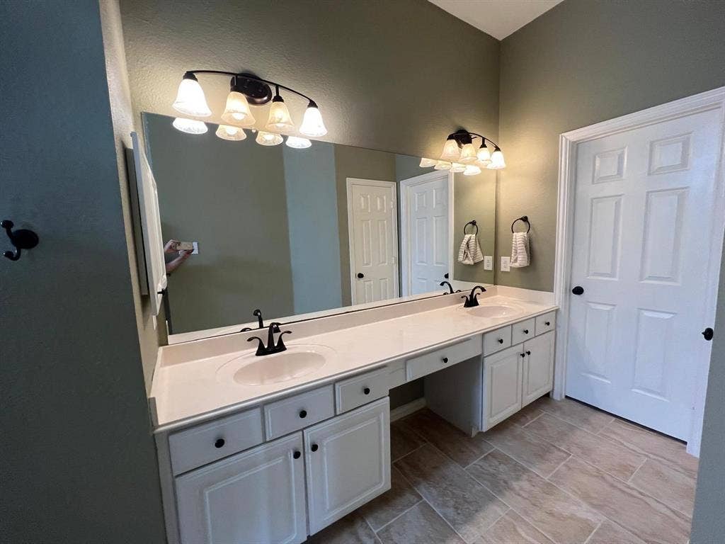 Dual sink vanity with white cabinetry and integrated countertops