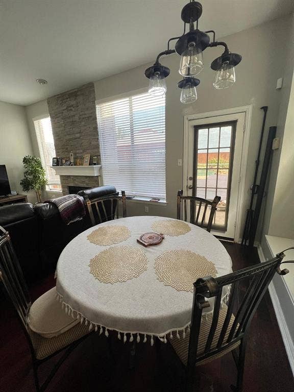Dining area with a multi-light chandelier, French-paned door, and dark wood-finish flooring