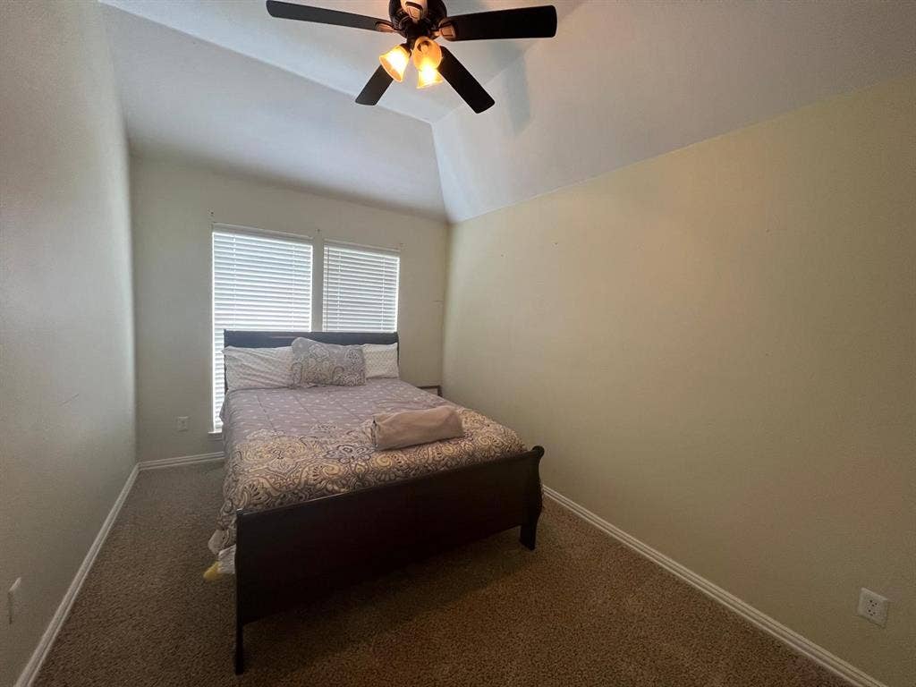 Room featuring a vaulted ceiling and a ceiling fan with integrated lighting