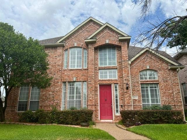 Brick facade residence featuring a two-story design and arched window accents