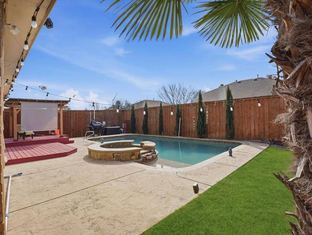 1039 Wood Brook Drive, Grand Prairie, TX 75052 In-ground pool featuring an integrated spa with stone surround