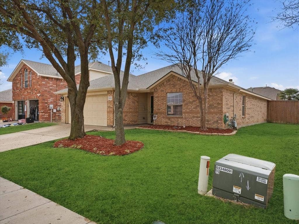 1039 Wood Brook Drive, Grand Prairie, TX 75052 Brick exterior with a light-colored garage door