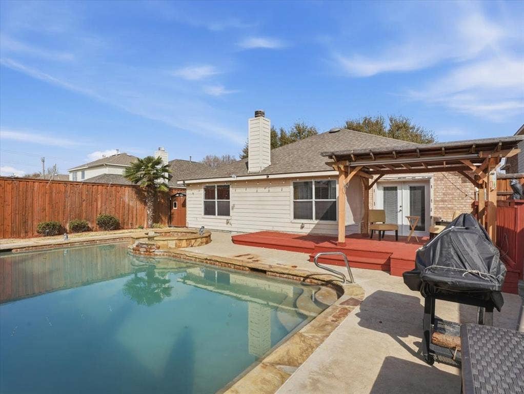 1039 Wood Brook Drive, Grand Prairie, TX 75052 Backyard featuring an in-ground swimming pool with stone coping and an integrated spa