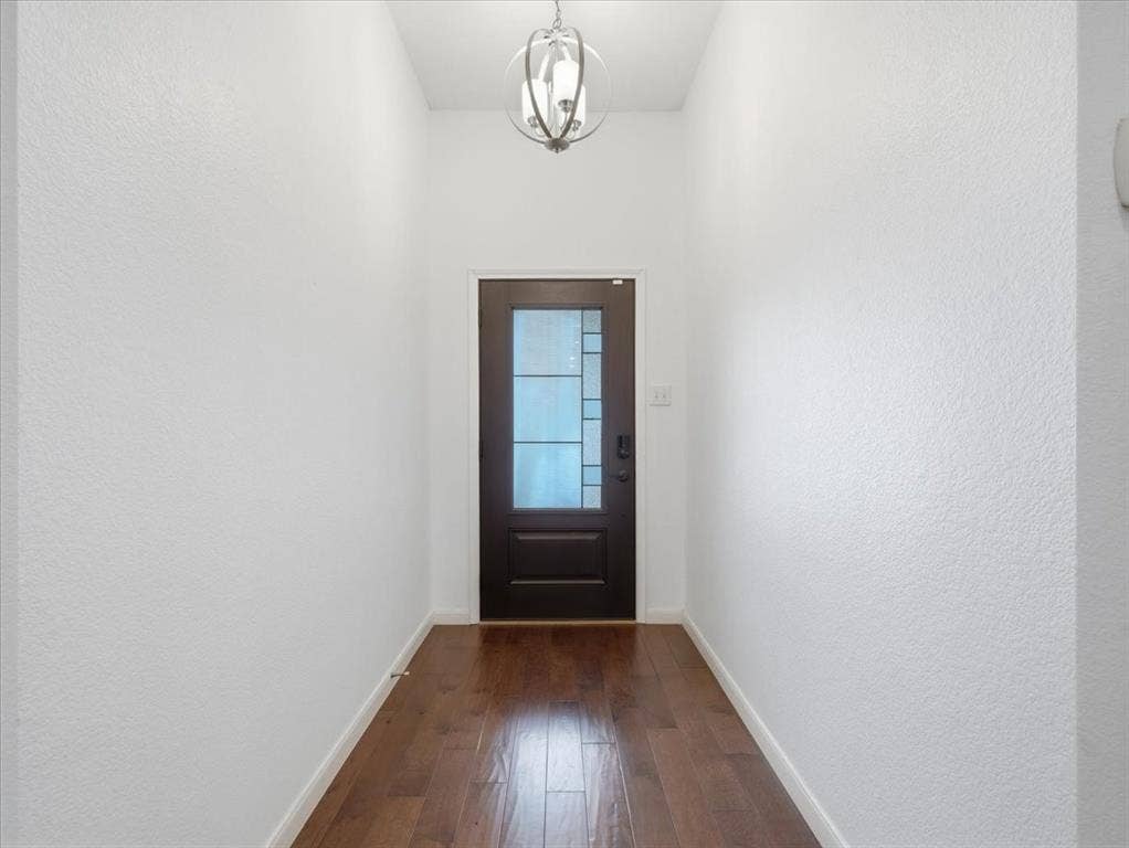 1039 Wood Brook Drive, Grand Prairie, TX 75052 Entryway featuring dark wood-finish flooring, a dark wood door with privacy glass, and a decorative ceiling light fixture