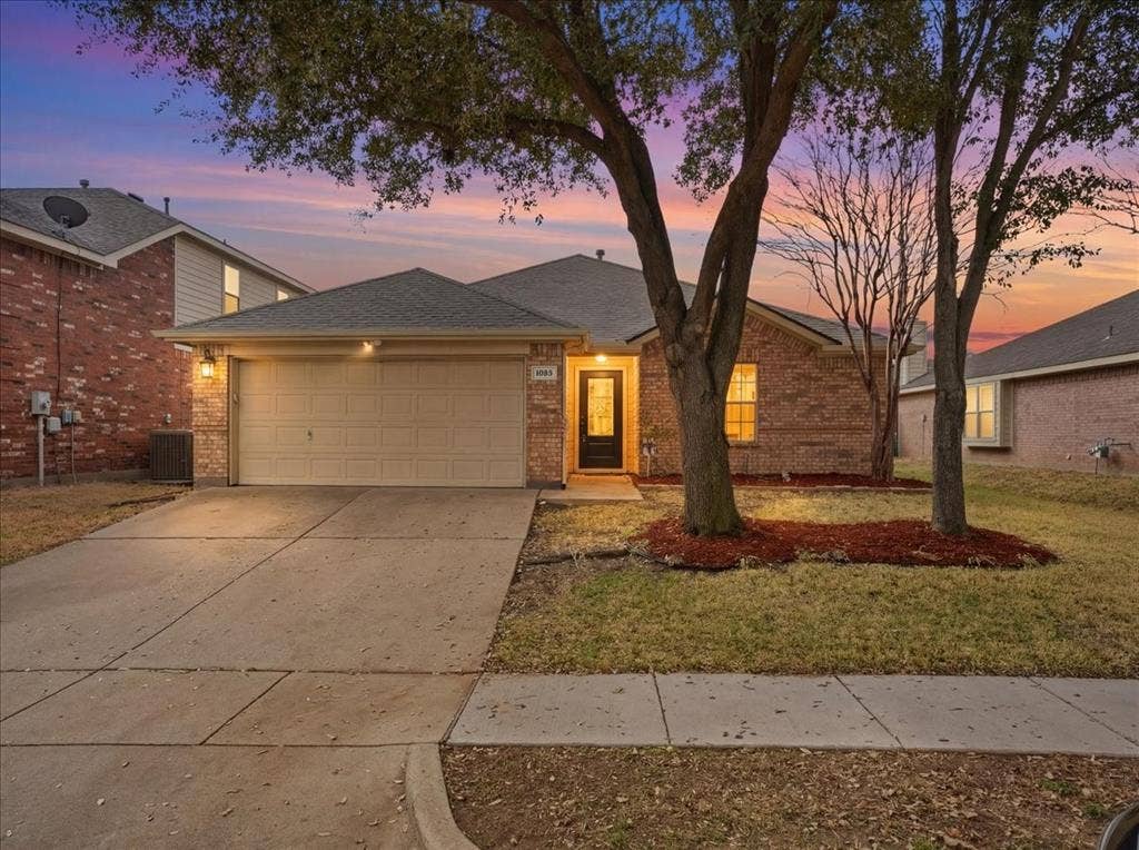 1039 Wood Brook Drive, Grand Prairie, TX 75052 Brick-clad exterior featuring an attached garage and a concrete driveway