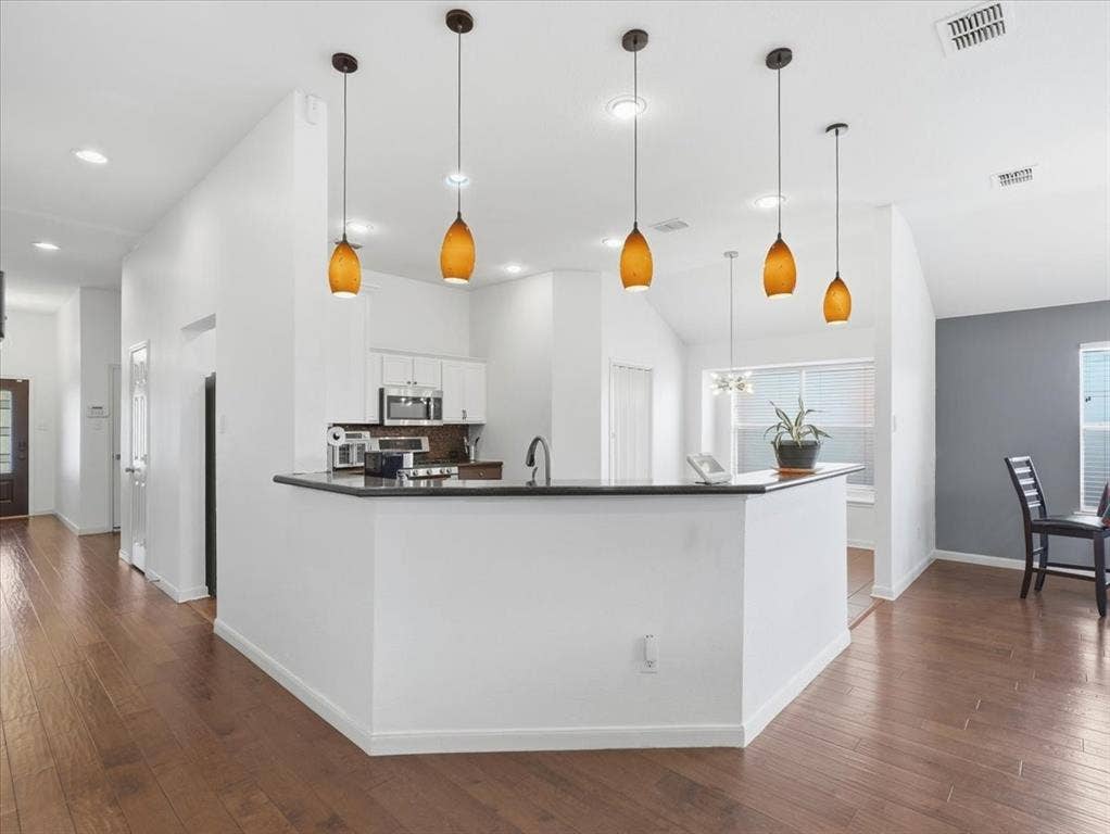 1039 Wood Brook Drive, Grand Prairie, TX 75052 Kitchen breakfast bar with a dark countertop and pendant lighting