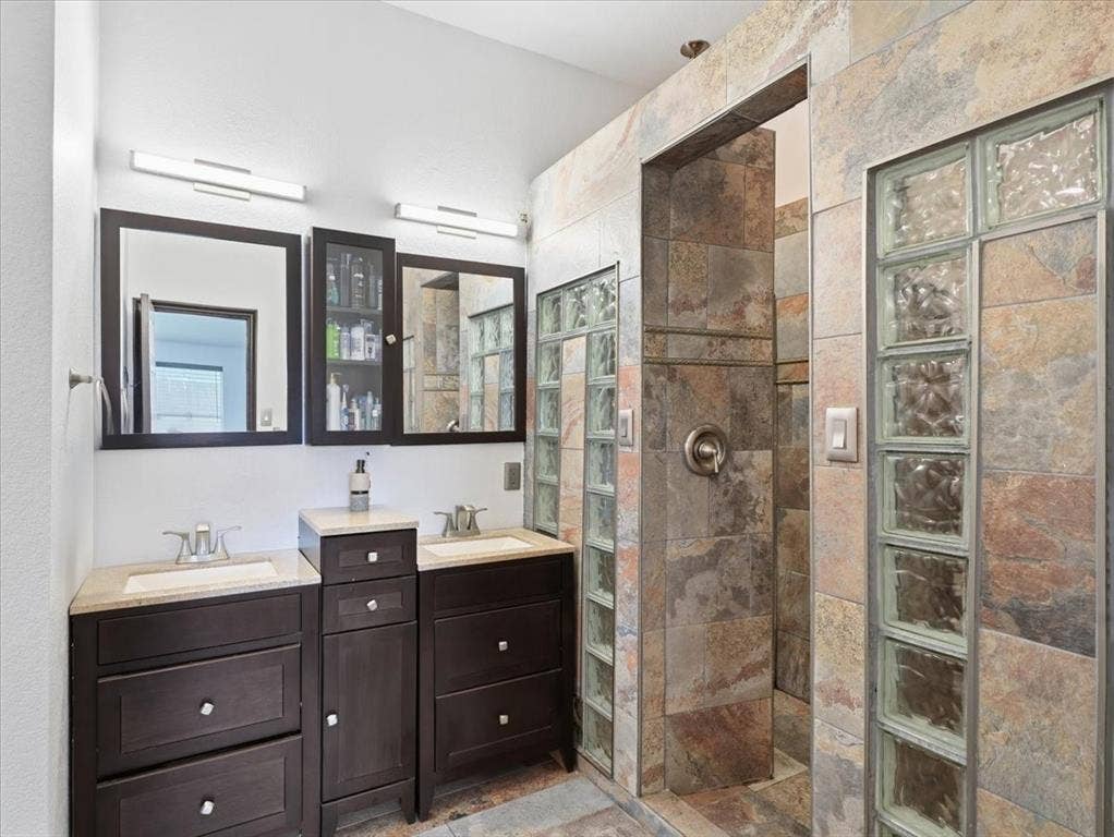 1039 Wood Brook Drive, Grand Prairie, TX 75052 Dual vanity with dark wood cabinetry, rectangular sinks, and light countertops