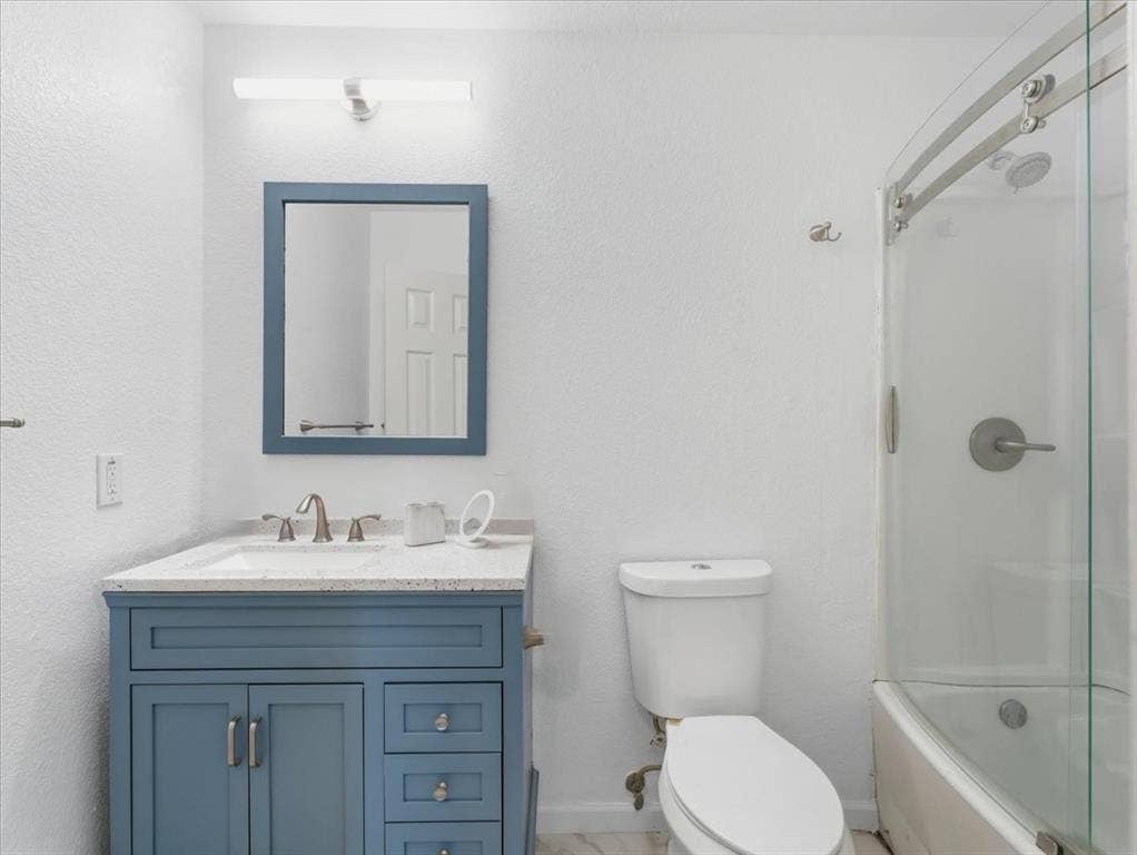 1039 Wood Brook Drive, Grand Prairie, TX 75052 Bathroom featuring a blue vanity with a white countertop, undermount sink, and brushed nickel faucet