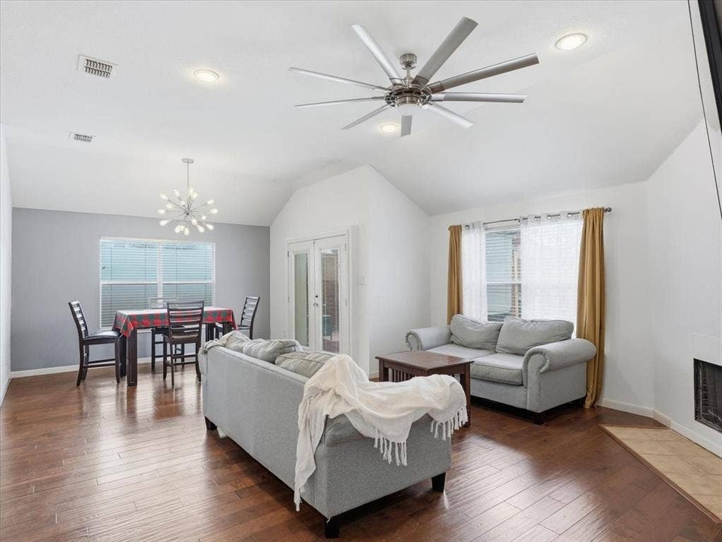 1039 Wood Brook Drive, Grand Prairie, TX 75052 Open-concept living and dining area featuring wood-finish flooring, a vaulted ceiling, and recessed lighting