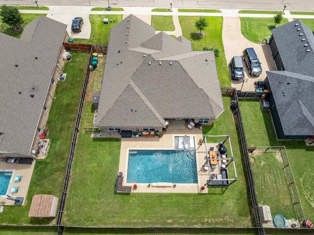 386 Cavitt Court, Robinson, TX 76706 Spacious fenced backyard featuring a rectangular swimming pool with surrounding patio, a covered outdoor living area, and expansive green lawn