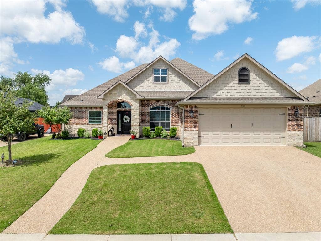 386 Cavitt Court, Robinson, TX 76706 Brick and stone facade featuring a gable roofline and a two-car garage
